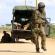 A Kenya Defense Force soldier runs for cover